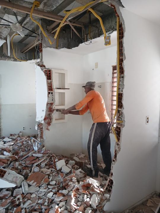 Profissional abrindo um vão em parede interna