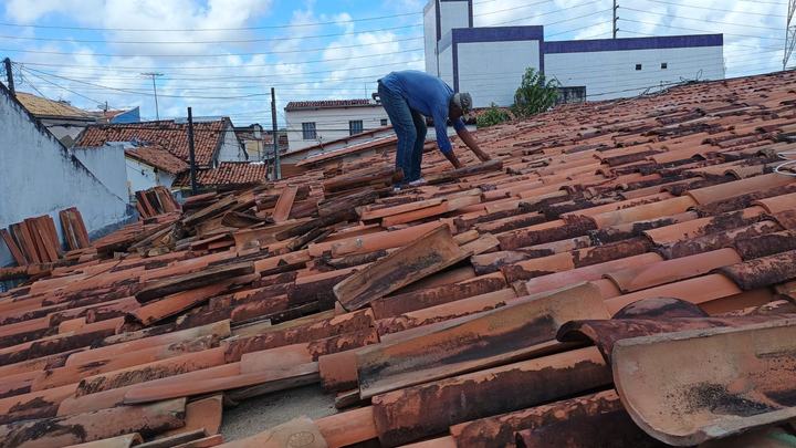 Profissional trocando telhas em um telhado